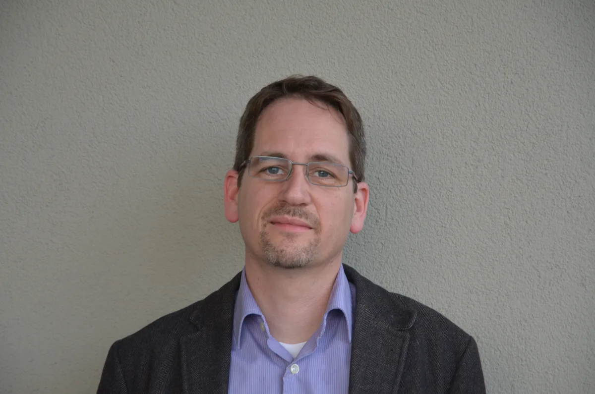 Porträt von Patrick Stark mit Hemd und Blazer.